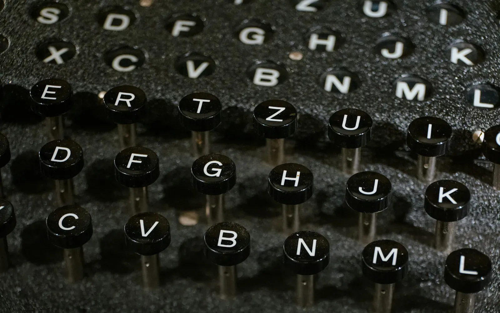 Nahaufnahme alter Schreibmaschinentasten mit weißen Buchstaben