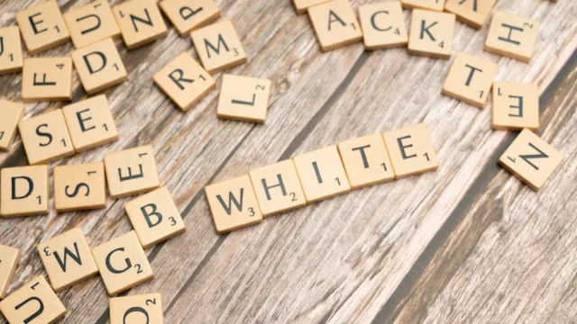 Verstreute Buchstabensteine auf einem Holztisch – Sexchat Abkürzungen erklärt