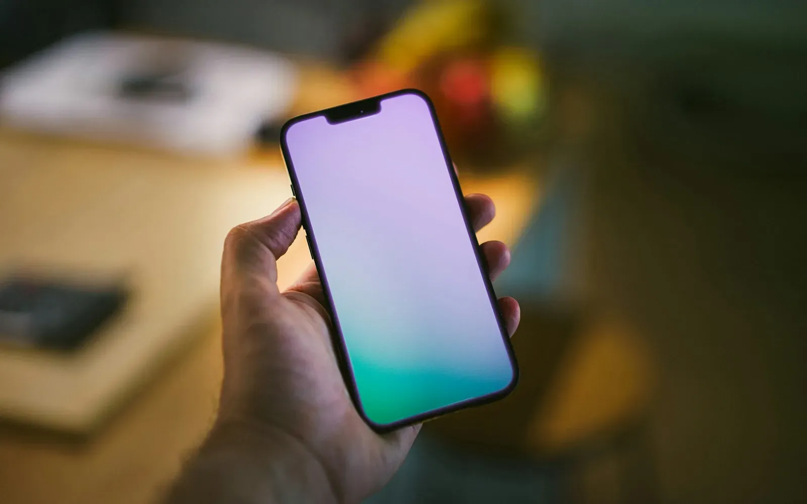 Hand hält ein leuchtendes Smartphone im gedämpften Abendlicht – Sexting Tipps