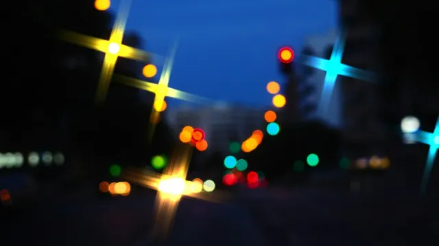 Unscharfe bunte Lichter einer Stadtstraße bei Nacht – Sextreffen in der Nähe finden